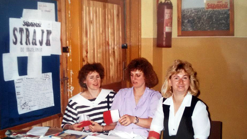 Fotografia przedstawia trzy kobiety siedzące przy stoliku